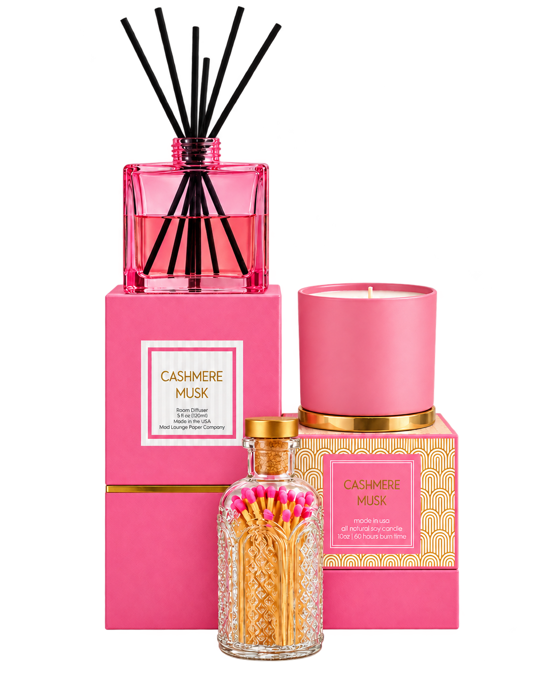 A fragrance gift set from Cashmere Musk by Longchamp, featuring a pink reed diffuser with black reeds, a pink candle, and a glass bottle of matches with pink and yellow wicks, all arranged on a white background.